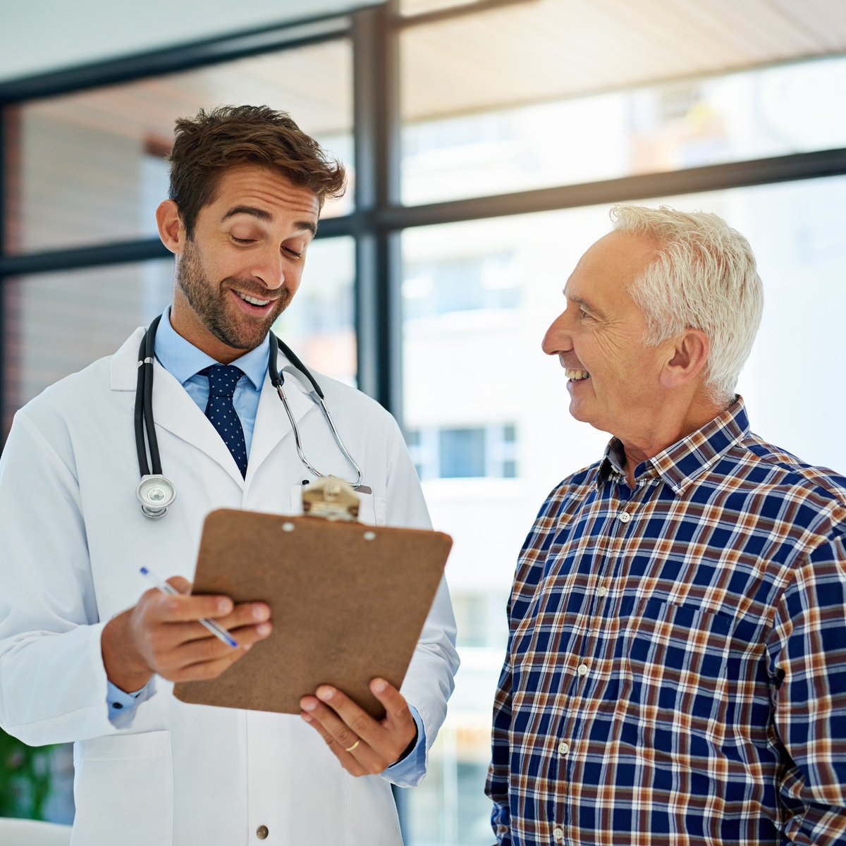 A cheerful doctor sharing good test results with a mature patient